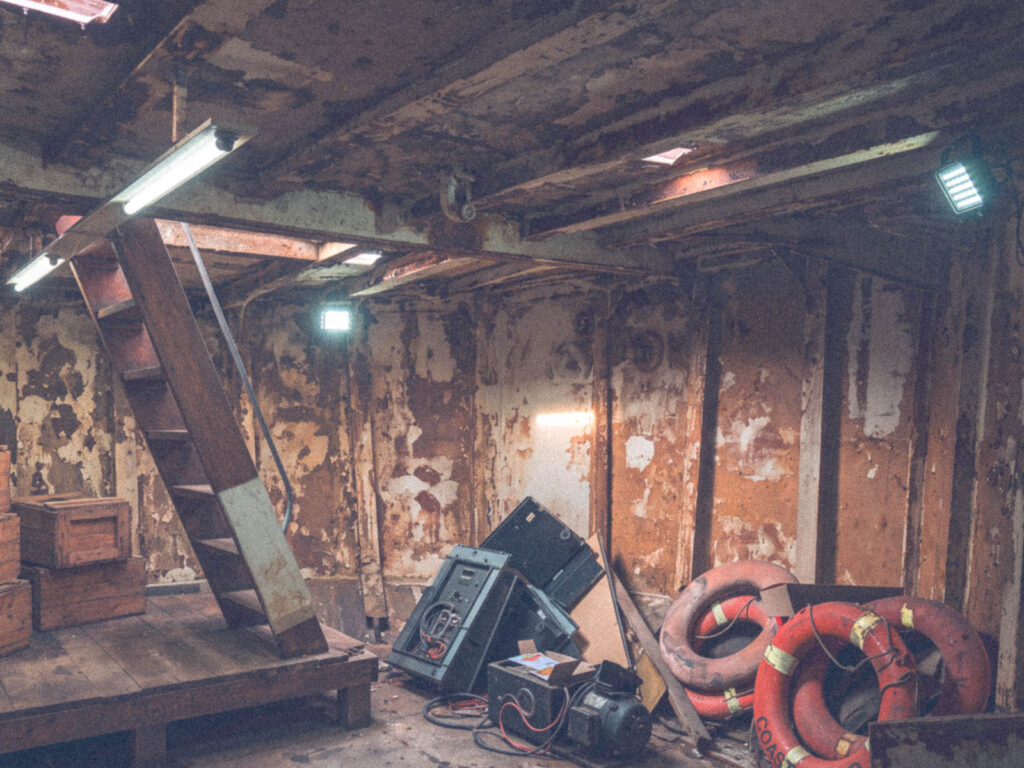 Exposed riveted metal plating and framing inside the barge