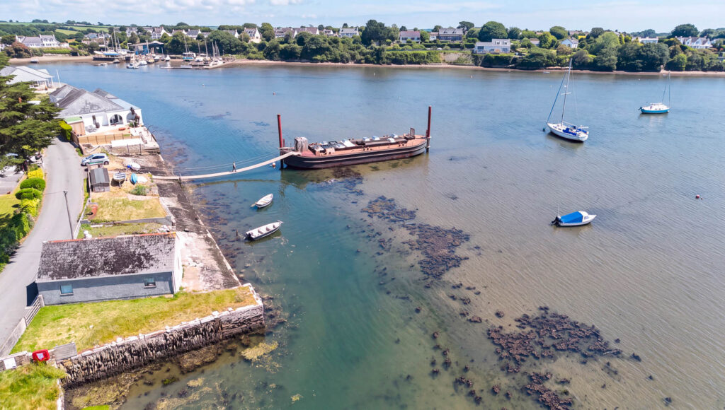 Traditional barge moored in a tidal harbour during conversion