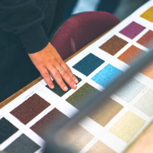 Hand touching textured cork colour samples on an ECOPROCORK swatch display board