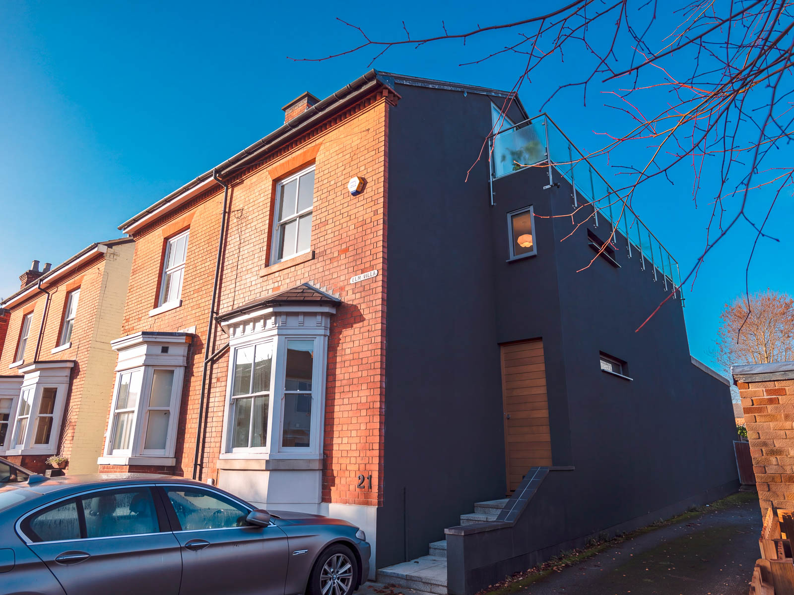 Victorian end-terrace home in Harborne with a dark cork-coated side elevation and red-brick frontage