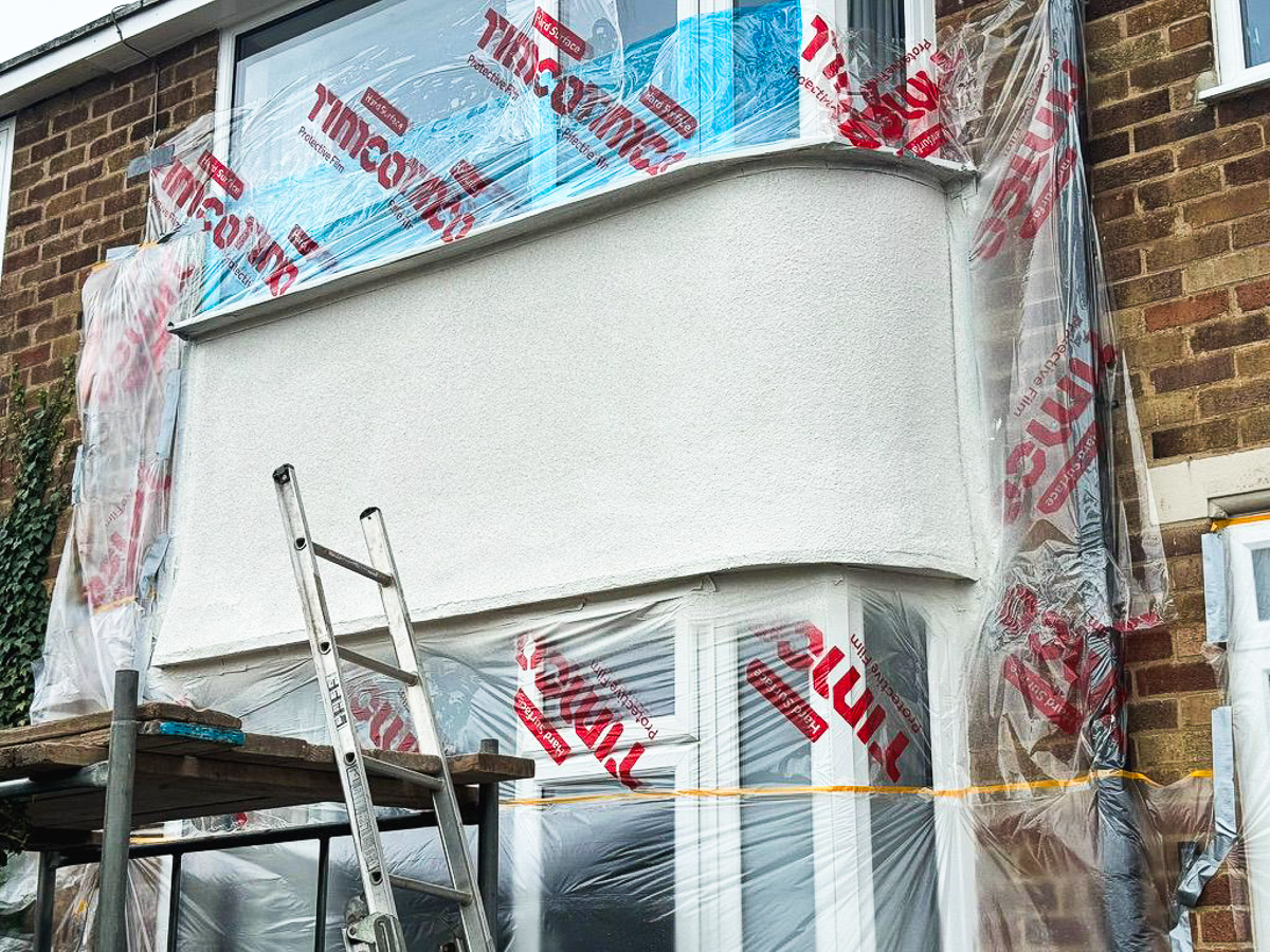 Bay window during application, with protective masking and access equipment in place