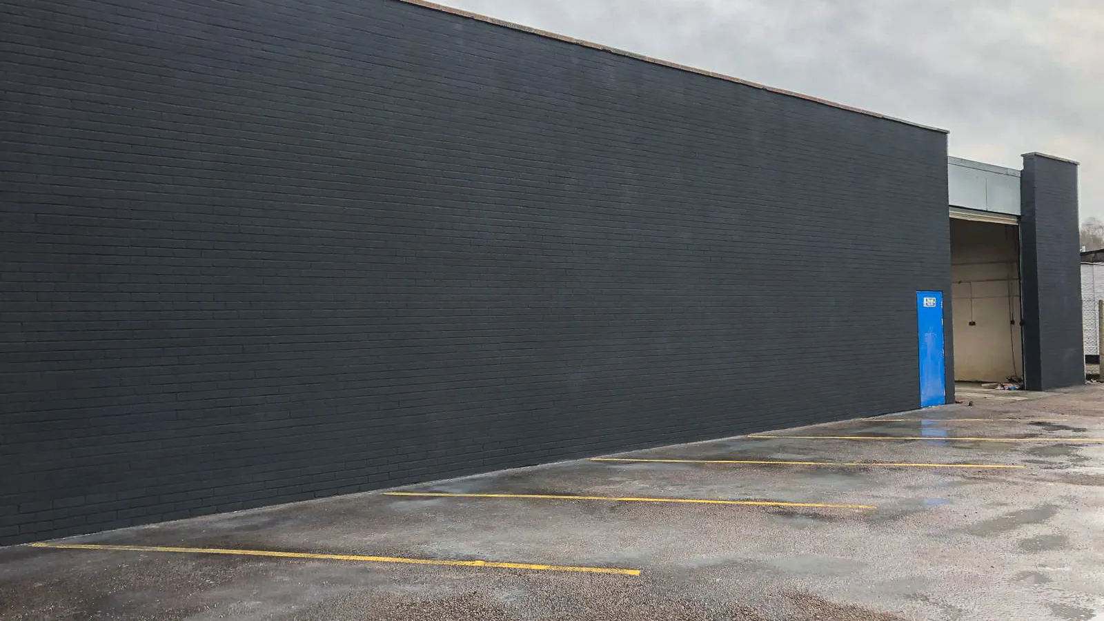Long factory wall with its completed charcoal finish