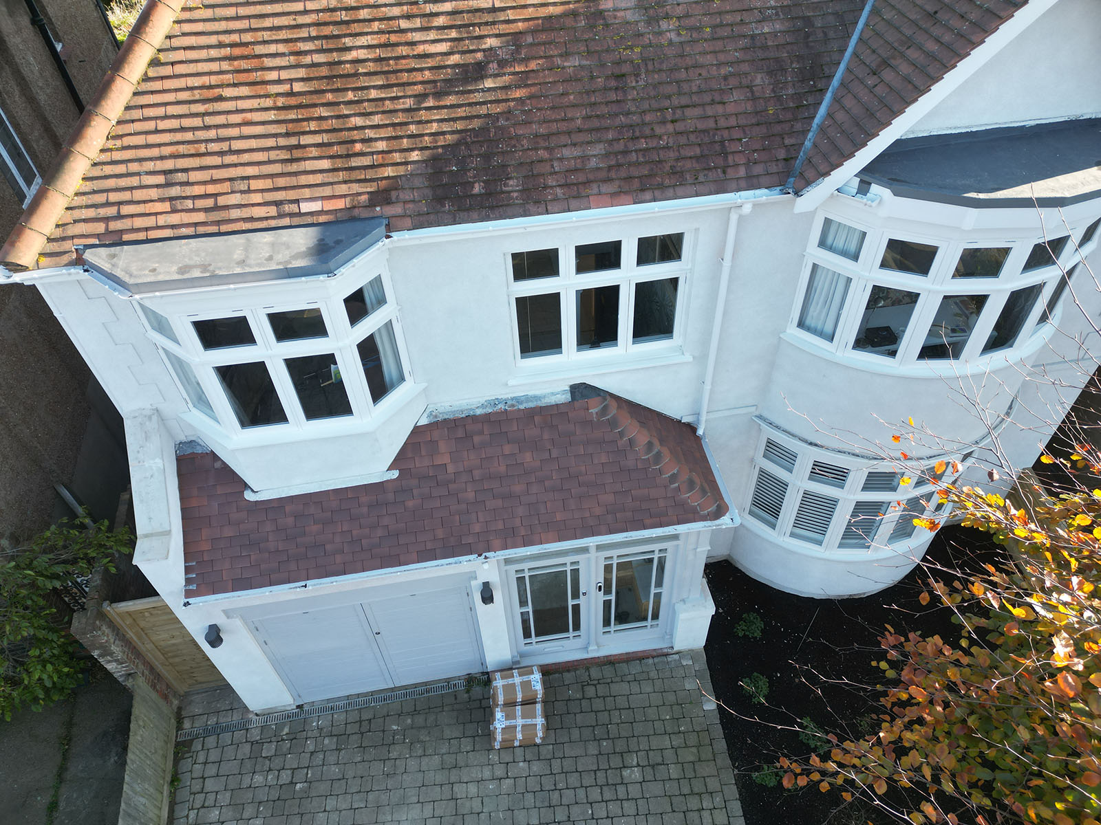 Completed white exterior at the Hove project, with bay windows and tiled roofs